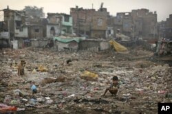 FILE- An Indian boy defecates in the open in a poor neighborhood of New Delhi, India, Nov. 6, 2012.