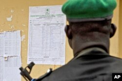 Un policier examinant les résultats de la présidentielle à Yenagoa, dans l'Etat de Bayelsa