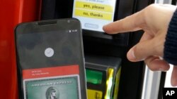 FILE - A Google employee gives a demonstration of Android Pay on a phone at Google I/O 2015 in San Francisco, May 28, 2015. 