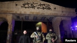 Syrian opposition fighters stand in front of University of Aleppo, after rebels opposed to President Bashar al-Assad said they had reached the heart of Aleppo