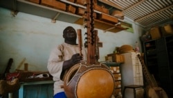 Frère Marie Firmin, 40 ans, joue de la kora à l'intérieur de l'atelier de fabrication de kora de l'abbaye de Keur Moussa, au Sénégal, le 19 mai 2021.