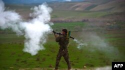 FILE - An Afghan National Army (ANA) soldier fires a rocket-propelled grenade (RPG) during a military operation in Badghis Province. The Taliban staged coordinated raids in two districts of northwestern Badghis province Sunday, killing 21 Afghan soldiers and police personnel.