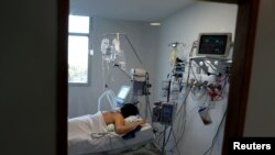 FILE - A patient suffering from the coronavirus disease (COVID-19) is seen in an intensive care unit of a hospital, on the outskirts of Buenos Aires, Argentina, Oct. 16, 2020. 