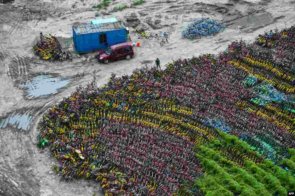 2017年8月24日在上海的一个临时停车场被遗弃的自行车。自行车分享行业已经被中国城市居民广泛使用，发展迅速，但共享单车迅猛成长也带来乱局丛生。当局做出规定，以防止未使用的自行车充斥街头。上海上周宣布禁止在城市为此投放更多的自行车，以防止人行道混乱。