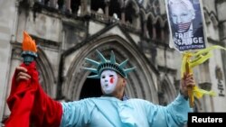 Pristalica Džulijana Asanža ispred suda u Londonu sa transparentnom na kojem se traži njegovo oslobađanje, 21. februar 2024. (REUTERS/Toby Melville)
