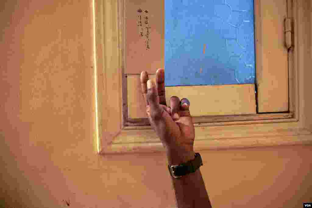 A sign hangs on a window inside the Cairo house of Sudanese refugees with trending revolutionary hashtags that say in Arabic &quot;Only step down, cities of Sudan revolts.&quot; (H. Elrasam/VOA)