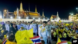 Raja Thailand Maha Vajiralongkorn (tengah kiri) dan Ratu Suthida (tengah kanan), melambaikan tangan ke arah para demonstran di Bangkok, Thailand, Minggu, 1 November 2020.