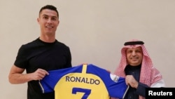 Pemain sepak bola Portugal Cristiano Ronaldo bersama Musalli Al-Muammar, presiden klub Arab Saudi Al-Nassr memegang baju klub setelah menandatangani kontrak yang berlaku hingga 2025. (Foto: via Reuters)