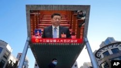 FILE - Chinese President Xi Jinping is seen on a live broadcast of the opening ceremony for the National People's Congress at a mall on March 5, 2022, in Beijing.