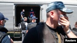 Petugas forensik mengumpulkan jenazah pesawat Malaysia Airlines MH17 sebelum diangkut dengan kereta menuju Belanda (22/7).