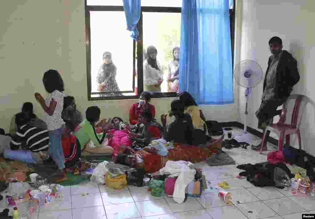 Suspected asylum seekers who were on a boat that capsized July 23, 2013, after hitting a reef, sit at a temporary shelter near Jayanti beach, West Java, Indonesia, July 24, 2013.&nbsp;