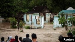 Warga mengamati banjir yang melanda wilayah mereka di Kampung Sewu, Solo, Jawa Tengah (19/6).