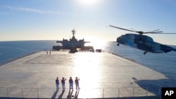Potongan gambar dari video yang dirilis oleh satuan tentara Iran pada 13 Januari 2021 ini menunjukkan sebuah helikopter mendarat di kapal logistik milik Angkatan Laut Iran dalam sebuah latihan militer. (Foto: Iranian Army via AP)