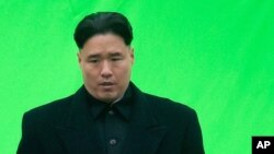 FILE - An actor playing North Korean leader Kim Jong Un waits ahead of filming for the movie "The Interview," at Robson Square in Vancouver, British Columbia.