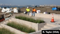 Construction workers rest on granite steps atop the Statue of Liberty museum, expected to open in May 2019.