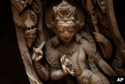 This photo taken July 19, 2017, shows detail of a wooden crafted window partly damaged during Nepal's 2015 earthquake. Woodworkers are now striving to restore parts of Nepal's heritage.