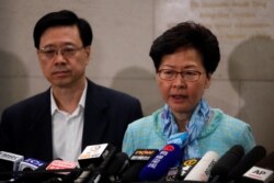 Hong Kong Chief Executive Carrie Lam, right, and Secretary for Security John Lee Ka-chiu speak to media over an extradition bill in Hong Kong, July 2, 2019.