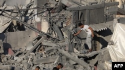 Warga Palestina berjalan di atas puing-puing bangunan yang hancur akibat pemboman Israel di kamp pengungsi Nuseirat, di Jalur Gaza tengah pada 30 Oktober 2023. (Foto: AFP)