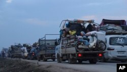 Truckloads of civilians flee a Syrian military offensive in Idlib province on the main road near Hazano, Syria, Dec. 24, 2019. 