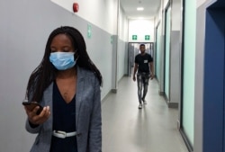 n Feb. 6, 2020, photo, a masked woman walks in a corridor of a shopping mall in Kitwe, Zambia.