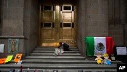 An anti-abortion activist places an image of Our Lady of Guadalupe alongside mock coffins at the entrance to the Supreme Court to celebrate the court's decision against an injunction aimed to decriminalize more abortions, in Mexico City, July 29, 2020.