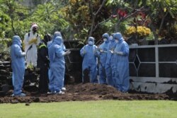 Petugas memakai baju hazmat dalam pemakaman Guru Besar UGM Prof Iwan Dwiprahasto di Makam Sawitsari Yogyakarta, Selasa 24 Maret 2020. (Foto: Courtesy/Humas UGM)