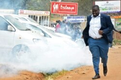 A man runs from teargas used to disperse supporters of Ugandan musician turned politician, Robert Kyagulanyi also known as Bobi Wine.