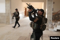 Iraqi special forces search a building located inside a church compound in Bartella, east of Mosul, Iraq on Oct. 21, 2016.