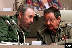 In this file picture taken on December 20, 1999 Cuban President Fidel Castro (L) confers with his brother Raul Castro