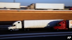 FILE - Trucks move along Interstate 35, in Laredo, Texas, Nov. 21, 2016.
