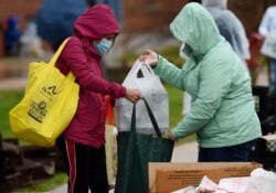Volunteers from the Baltimore Hunger Project pass out food to people in need outside of Padonia International Elementary school on Dec. 4, 2020, in Cockeysville, Maryland. More children are going hungry in the US as it weathers the coronavirus.