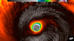 This false-color satellite image provided by the National Oceanic and Atmospheric Administration (NOAA) shows the moment the eye of Super Typhoon Yutu passed over Tinian, one of three main islands in the U.S. Commonwealth of the Northern Mariana Islands, producing damaging winds and high surf Oct. 24, 2018. 
