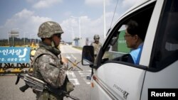 Binh sĩ Hàn Quốc kiểm tra xe cộ tại 1 trạm kiểm soát trên cầu Đại Thống nhất dẫn tới làng Bàn Môn Điếm, phía nam khu phi quân sự (DMZ) ngăn cách hai miền Triều Tiên, ở Paju, Hàn Quốc, 22/8/2015.