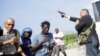 People run as Haiti's Senator Jean Marie Ralph Fethiere holds a gun in Port-au-Prince, Haiti, Sept. 23, 2019.