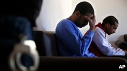 FILE - Alexanda Kotey, left, and El Shafee Elsheikh, who were allegedly among four British jihadis who made up a brutal Islamic State cell dubbed "The Beatles," are interviewed by The Associated Press at a security center in Kobani, Syria, March 30, 2018.