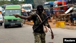 Un mutin fait un geste à un poste de contrôle de l'entrée de Bouaké, Côte d'Ivoire, 15 mai 2017.