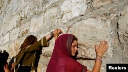 Une femme touche le mur des Lamentations, à Jérusalem, le 21 juin 2009. (Photo: REUTERS/Ammar Awad)