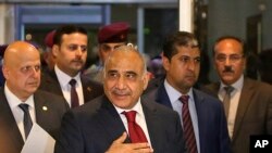 Prime Minister-designate Adel Abdul-Mahdi, center, arrives to the parliament building, in the heavily guarded Green Zone, in Baghdad, Iraq, Oct. 24, 2018. 