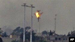 A warplane is seen being shot down over the outskirts of Benghazi, eastern Libya, March 19, 2011