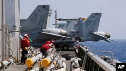 AL AS di kapal induk USS Carl Vinson (CVN 70) bersiap memindahkan misil ke jet tempur F-18 sebelum patroli rutin di Laut China Selatan, 3 Maret 2017.