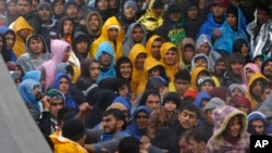 Para migran menunggu di perbatasan Kroasia-Serbia di kota Babska, Kroasia Senin (19/10).