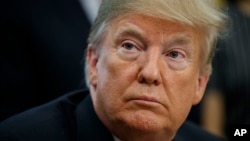 FILE - President Donald Trump listens to a question during a ceremony in the Oval Office of the White House in Washington, Oct. 11, 2018.