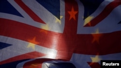 FILE - Anti-Brexit demonstrators wave EU and Union flags outside the Houses of Parliament in London, Jan. 30, 2018. 