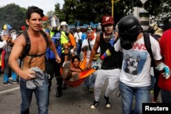 An injured opposition supporter is helped by others during a rally against President Nicolas Maduro in Caracas, Venezuela, May 3, 2017.