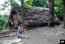 FILE - A woman weaves a mat in a village on Tanna Island in Vanuatu, June 2, 2015. Tanna Island was particularly hard hit by Cyclone Pam, which struck in March of that year. Many people in Vanuatu believed the cyclone was the latest manifestation of climate change's effect on the area.