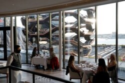 Orang-orang duduk di restoran seafood Mediterania Estiatorio Milos di Hudson Yards ketika restoran mulai membuka kembali layanan makan di dalam ruangan dengan kapasitas 25 persen di Manhattan, New York City, AS, 30 September 2020. (Foto: REUTERS/Andrew Ke