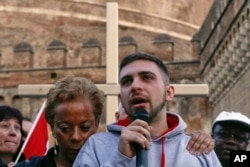 Sex abuse survivor Alessandro Battaglia, right, is hugged by survivor and founding member of the ECA (Ending Clergy Abuse), Denise Buchanan, as he speaks during a twilight vigil prayer near Castle Sant' Angelo, in Rome, Feb. 21, 2019.