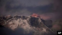 FILE - In this Oct. 27, 2011 file photo, the last light of the day sets on Mount Everest as it rises behind Mount Nuptse as seen from Tengboche, in the Himalaya's Khumbu region, Nepal.