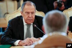 Russian Foreign Minister Sergey Lavrov listens to U.S. Secretary of State Rex Tillerson, right back to the camera, during their talks in Moscow, Russia, April 12, 2017.