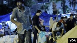 At the edge of the pro-Morsi camp, men shovel sand in bags to pile around their tent city, July 29, 2013. Protesters say they believe sand will stop bullets better than the brick walls they erected over the weekend. (Hamada Elrasam/VOA)